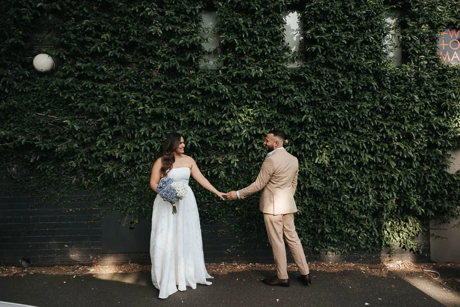 Couple portrait against an ivy wall